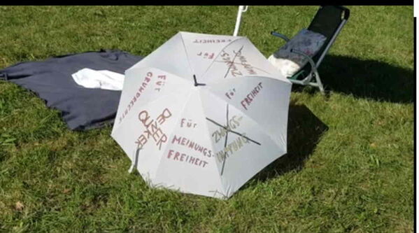 Weißer Schirm mit dunkler Aufschrift