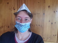 Demovorbereitung: OP-Maske über Mund und Nase - FFP-2 Maske auf dem Kopf als Hütchen, beschriftet