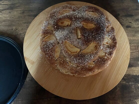 Die Äpfel auf dem Kuchen stellen ein schmunzelndes Gesicht dar
