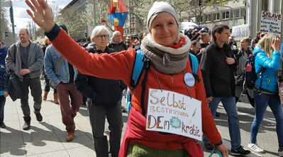 Winkende Frau mit Plakat