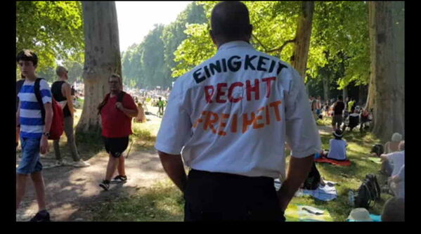 Ein Mann im weißen Shirt. Die Rückseite bedruckt