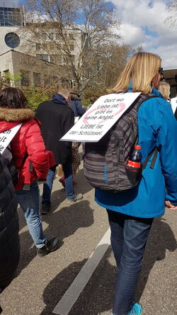 Fußgängerin mit Plakat rücklings
