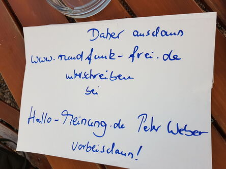 Hinweisplakat auf einem Tisch zur Unterschriftensammlung