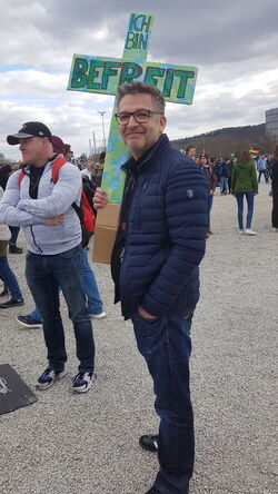 Mann mit einem Kreuz aus Karton