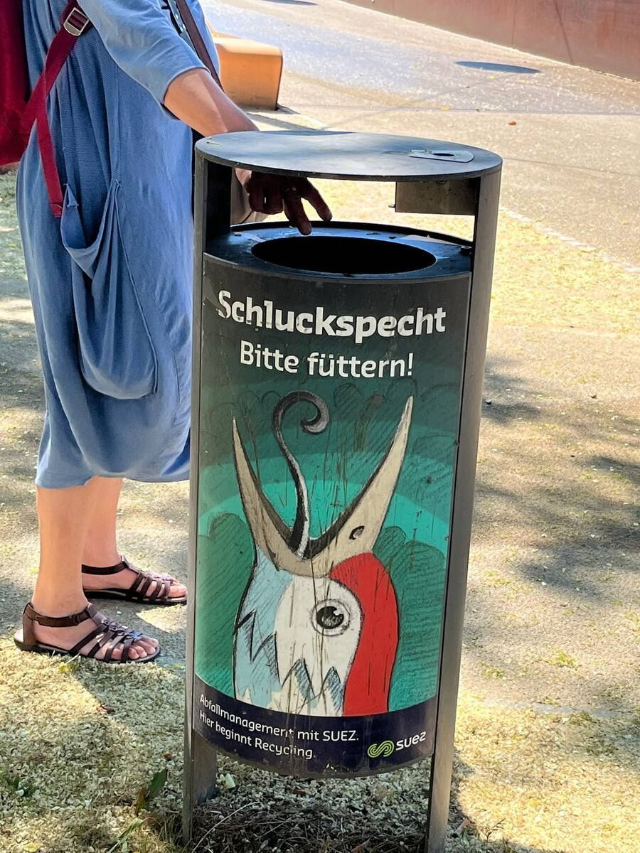 Mülleimer mit Specht der den Schnabel aufreißt